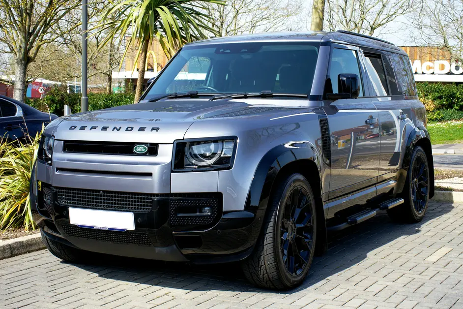 Land Rover Defender fährt durch schlammiges Gelände