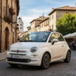 Red Fiat 500 Cabrio with open roof driving through a European city street on a sunny day